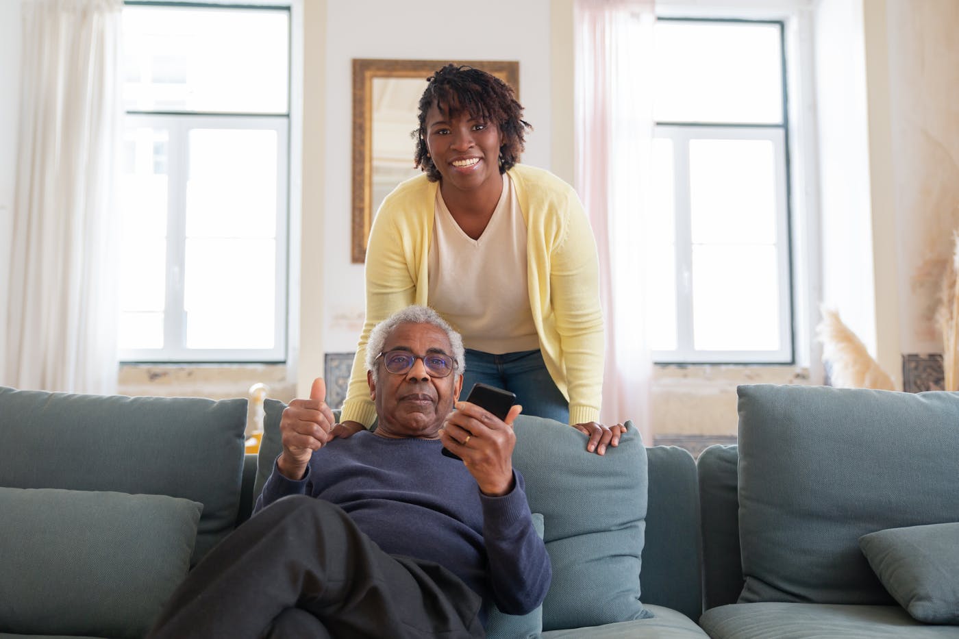 A support worker smiling with an older man she cares for at home